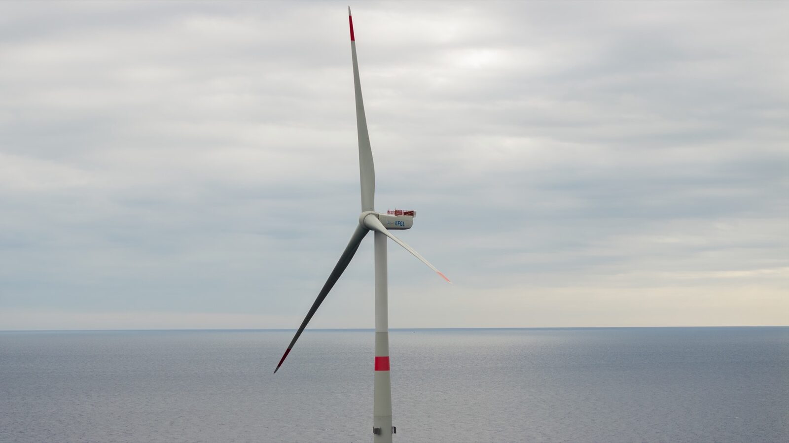 A floating offshore wind turbine at sea, filmed from the water